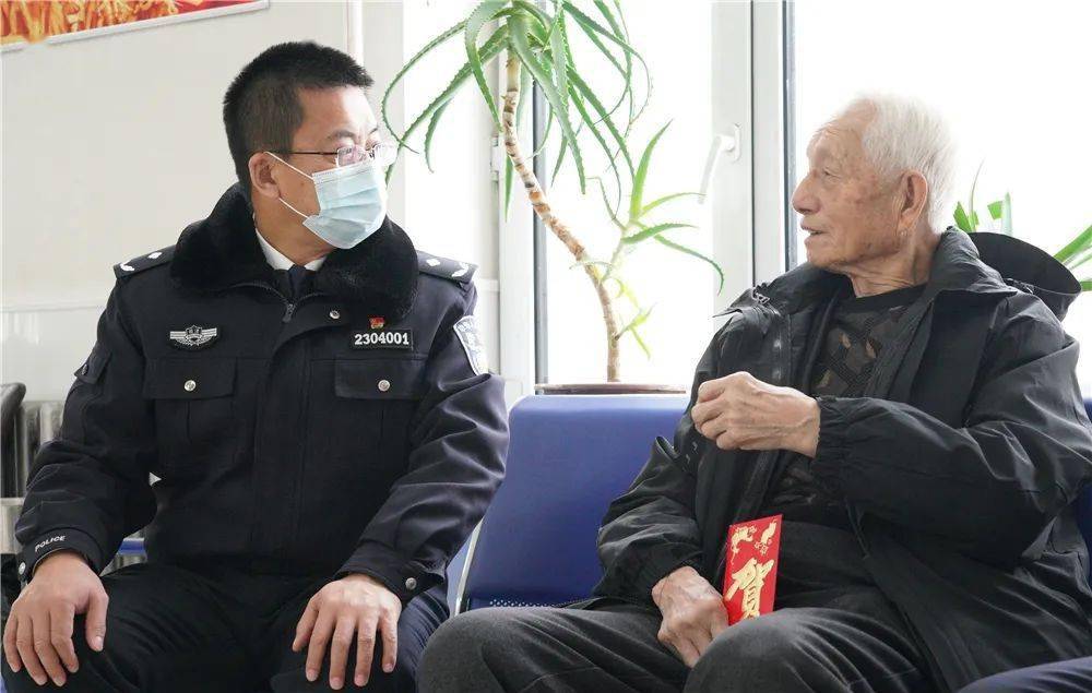 图:北安监狱党委书记,监狱长魏朝军在走访慰问时,与退休老干部滕万英