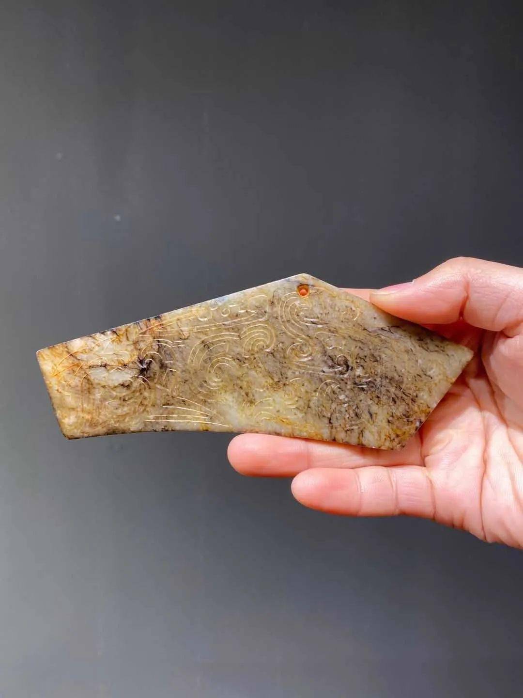 古代祭祀时打击乐器磬,以质地细腻油润的新疆和田褐沁斑白玉雕刻而成