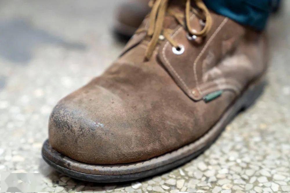 这不是普通的运动鞋,而是特制的劳保鞋——鞋尖有钢板,底部有钢钉