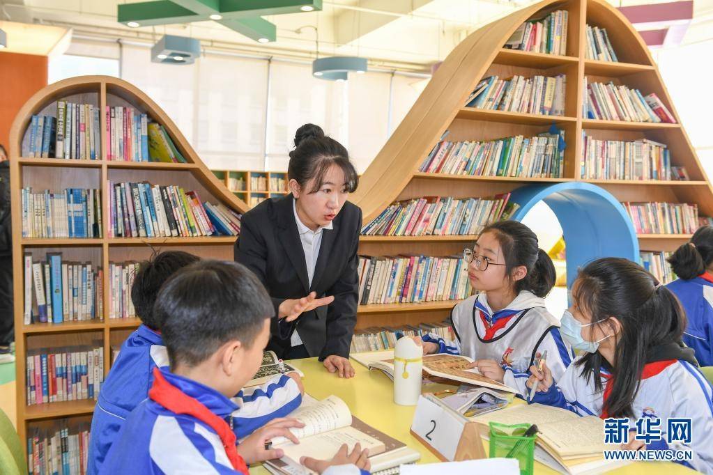 3月25日,在长春市第八十七中学图书馆,小学部教师孙铭辅导学生阅读