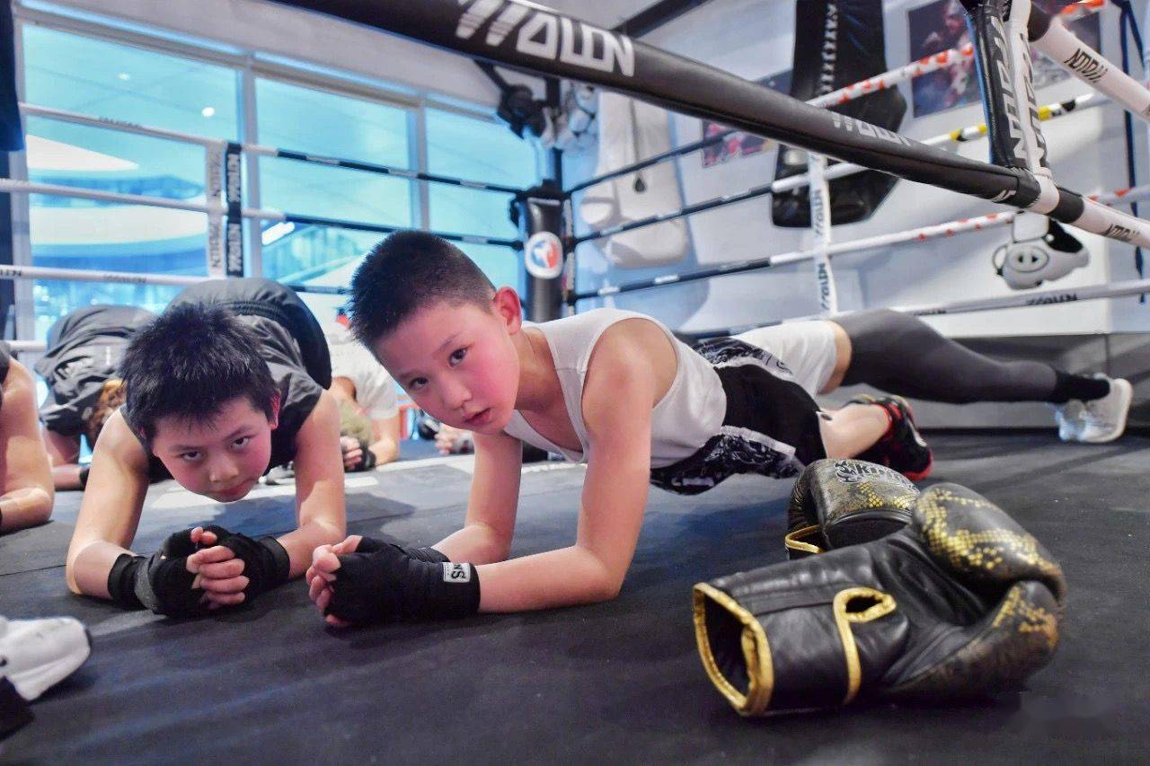 成人团课上,小男孩一起接受成人力量训练.