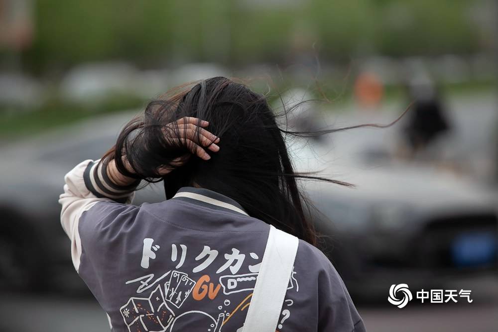 北京冷风呼呼吹街头行人厚装出行泥点车排长队