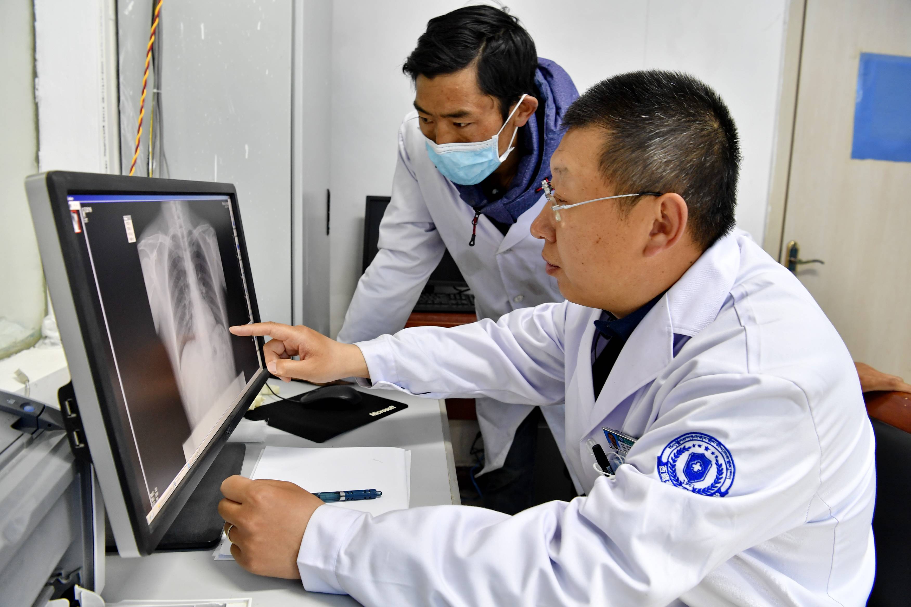 批援藏医疗队成员赵文雷(右)指导当地医院放射科助理医师普布次仁看片