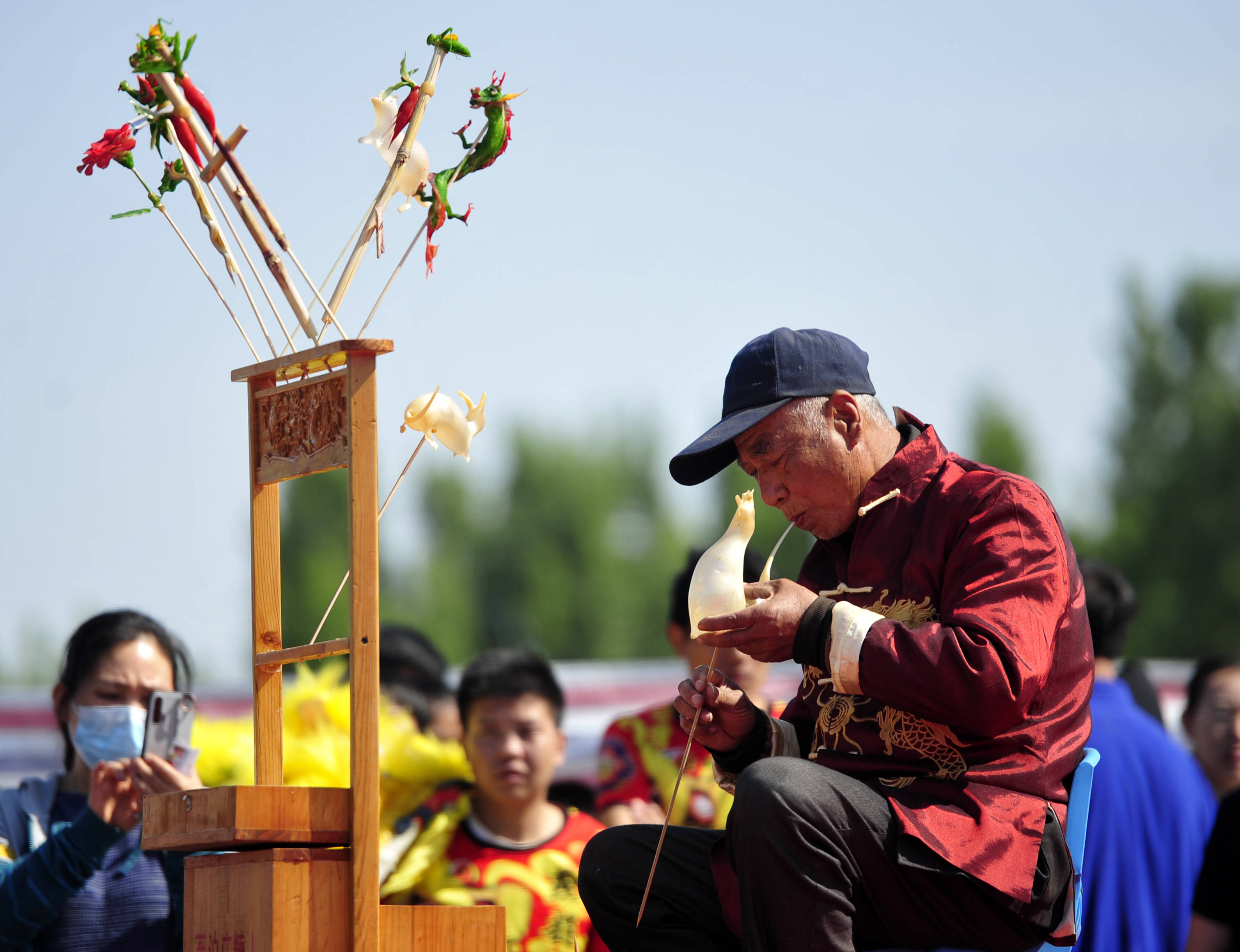 5月2日,艺人在肃宁县西泊庄牡丹文化园表演吹糖人