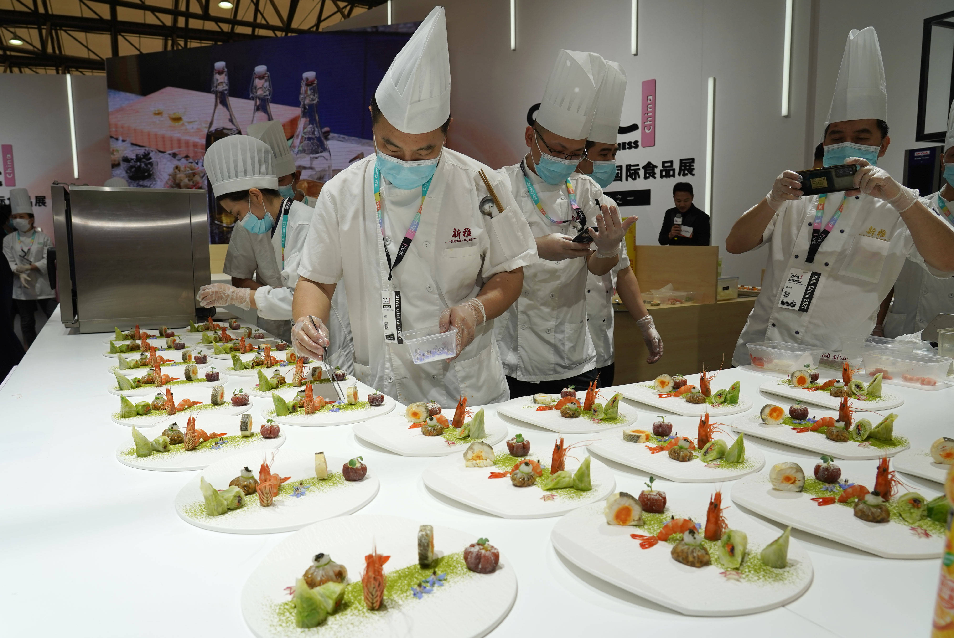 参加"名厨盛宴"的上海一家粤菜馆厨师在展会现场制作美食供来宾品尝