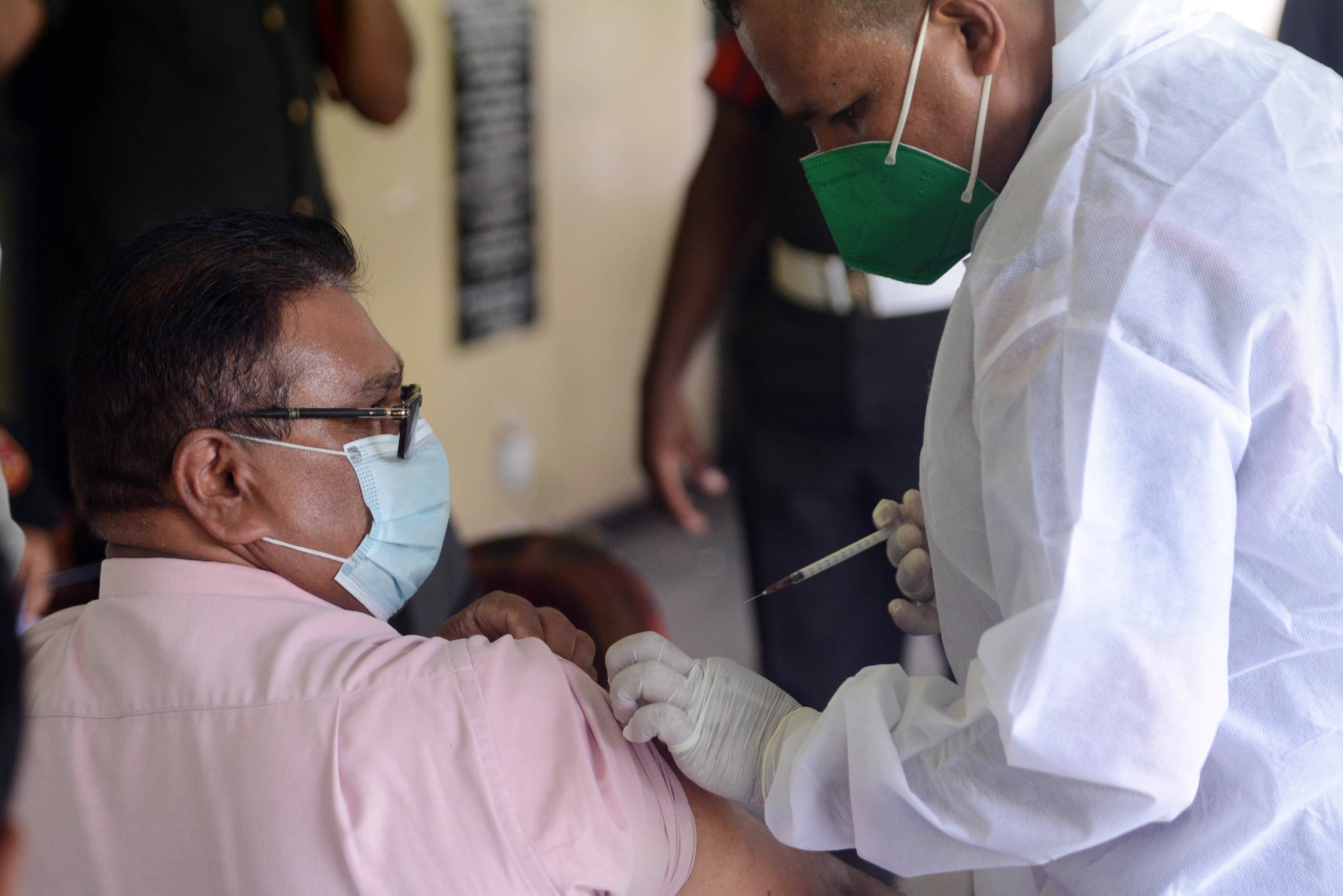 5月20日,一名男子在斯里兰卡科伦坡的一处疫苗接种中心接种新冠疫苗.