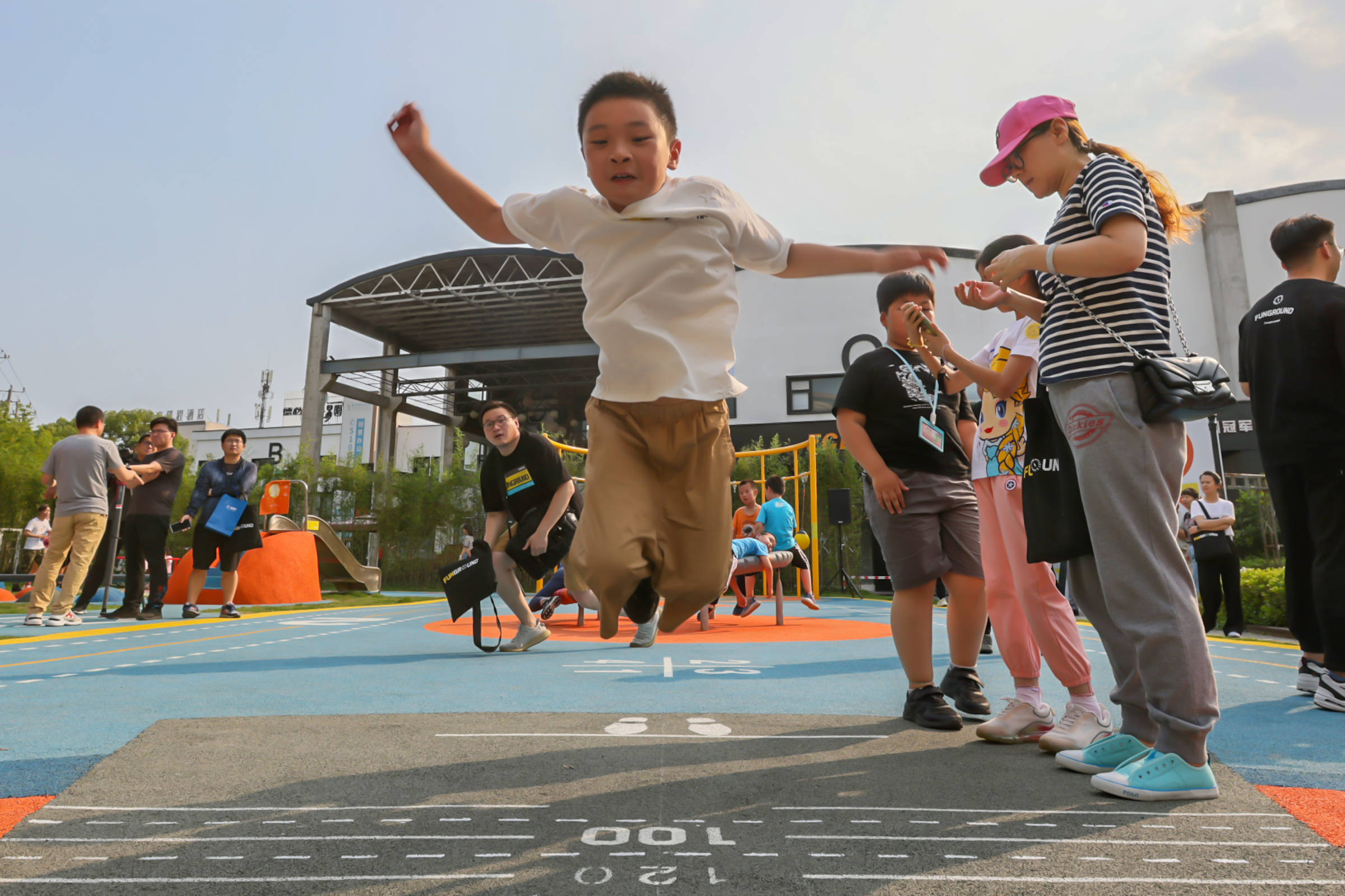 5月30日,小朋友在ai社区运动公园进行立定跳远.