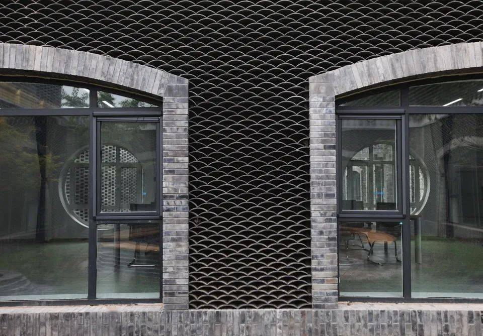 中:外墙上的彩虹状砖拱,内院里的波浪纹叠瓦以及祥云图案的金属挂板