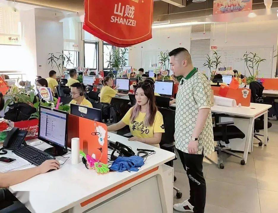 在线营销事业部工作区的一个工位上,钟晨与商标顾问小姐姐交流品牌