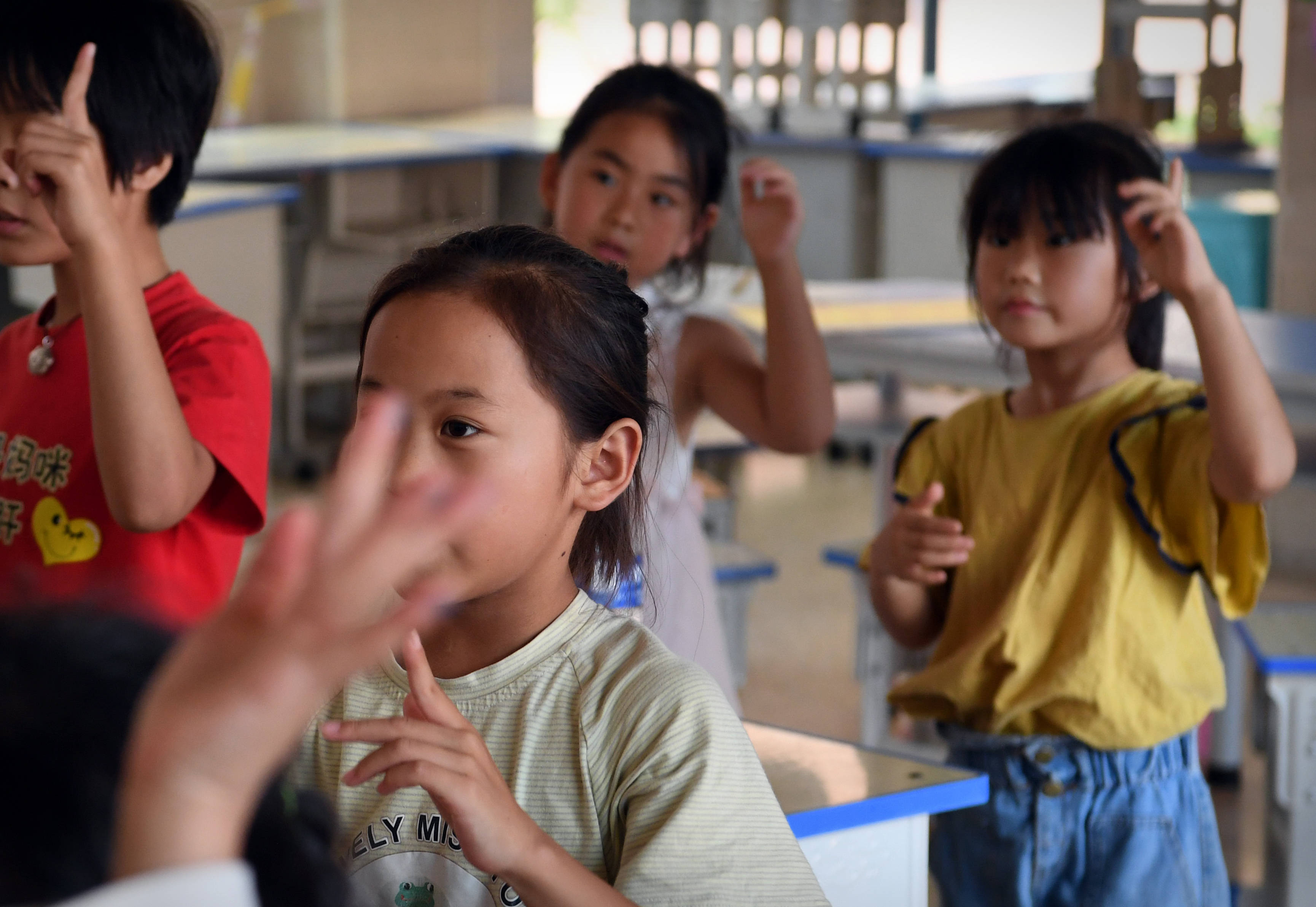 7月29日,在鹤壁市浚县黎阳中学长丰校区安置点,小朋友在志愿者的带领