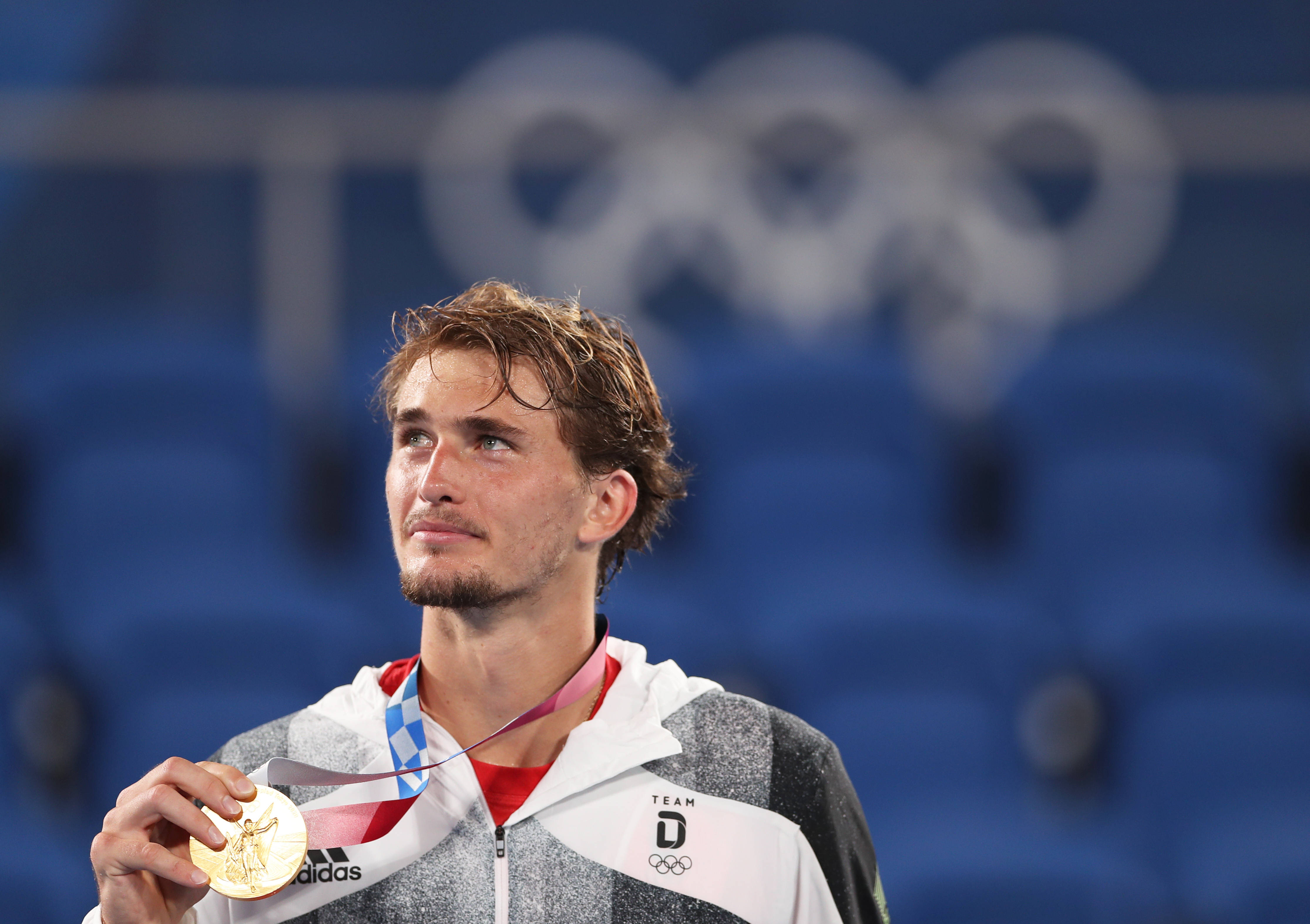 8月1日,德国选手兹维列夫在网球男子单打决赛后的颁奖仪式上展示金牌.