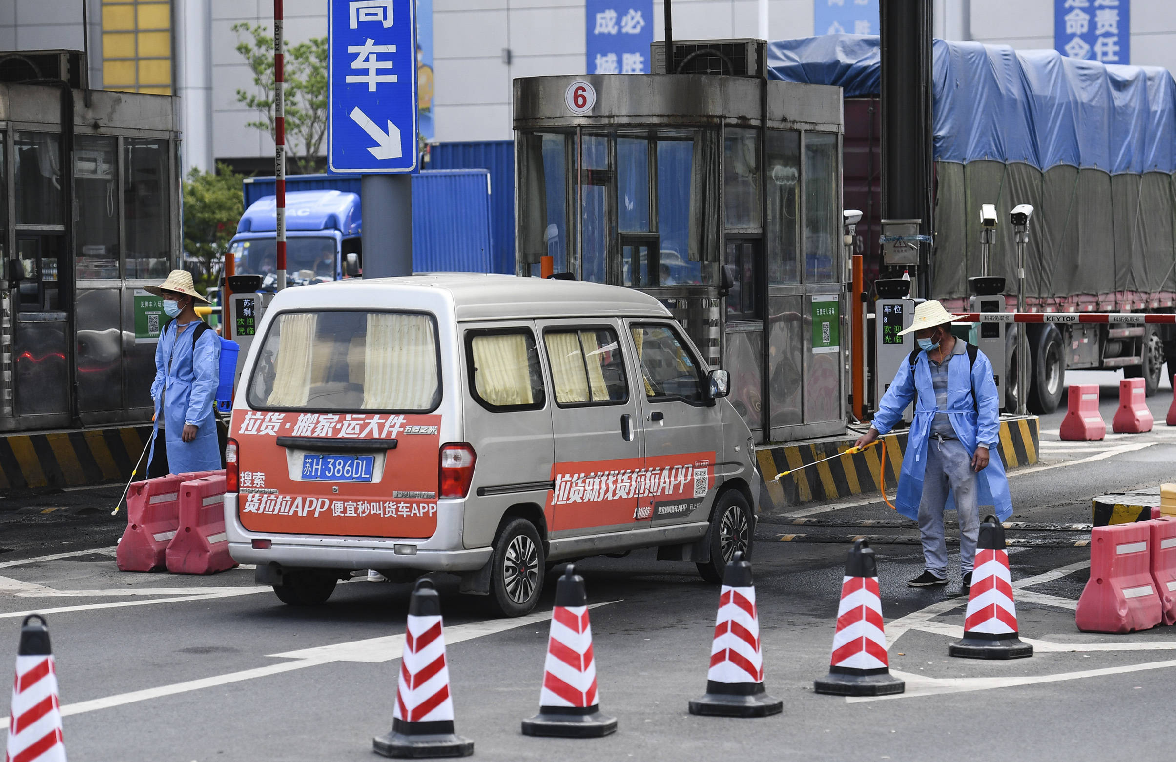 8月3日,在南京农副产品物流配送中心,工作人员在对进入车辆消毒.