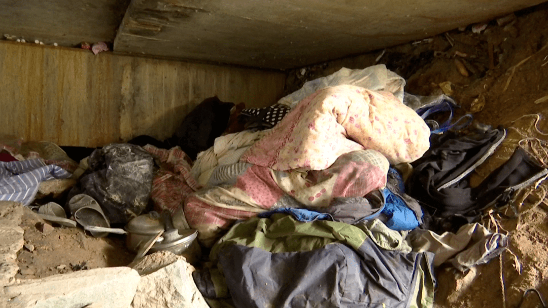 新城勾山浦桥桥洞里放置着被子,衣服,锅,盆,蚊香,牙膏,针线包等生活