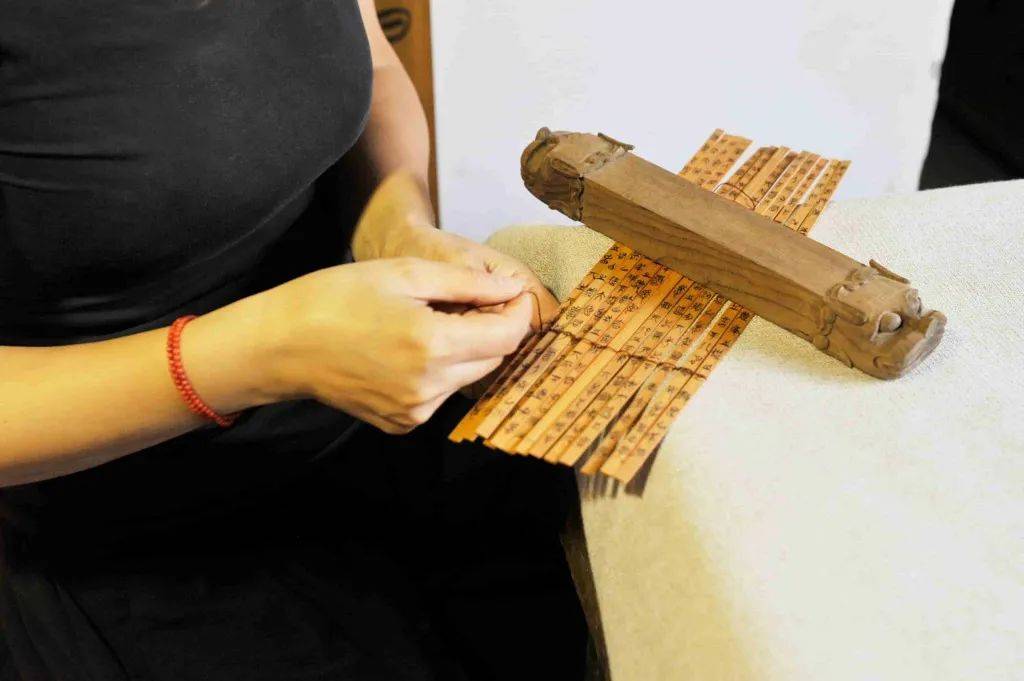 通过制作毛坯,蒸煮晾干,文字书写,编联成册等工序制成竹简的传统工艺