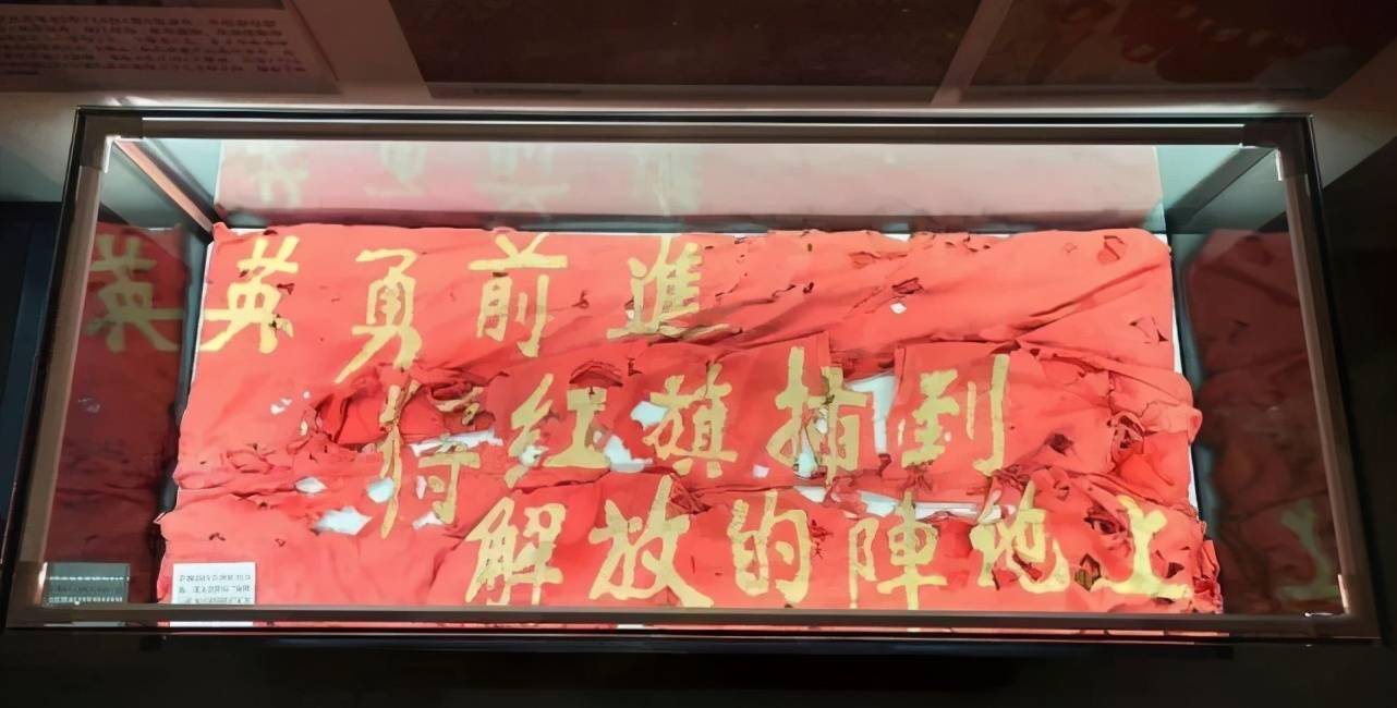 牢牢插在主峰阵地将布满381个弹孔的战旗"上甘岭特功八连"上甘岭激战