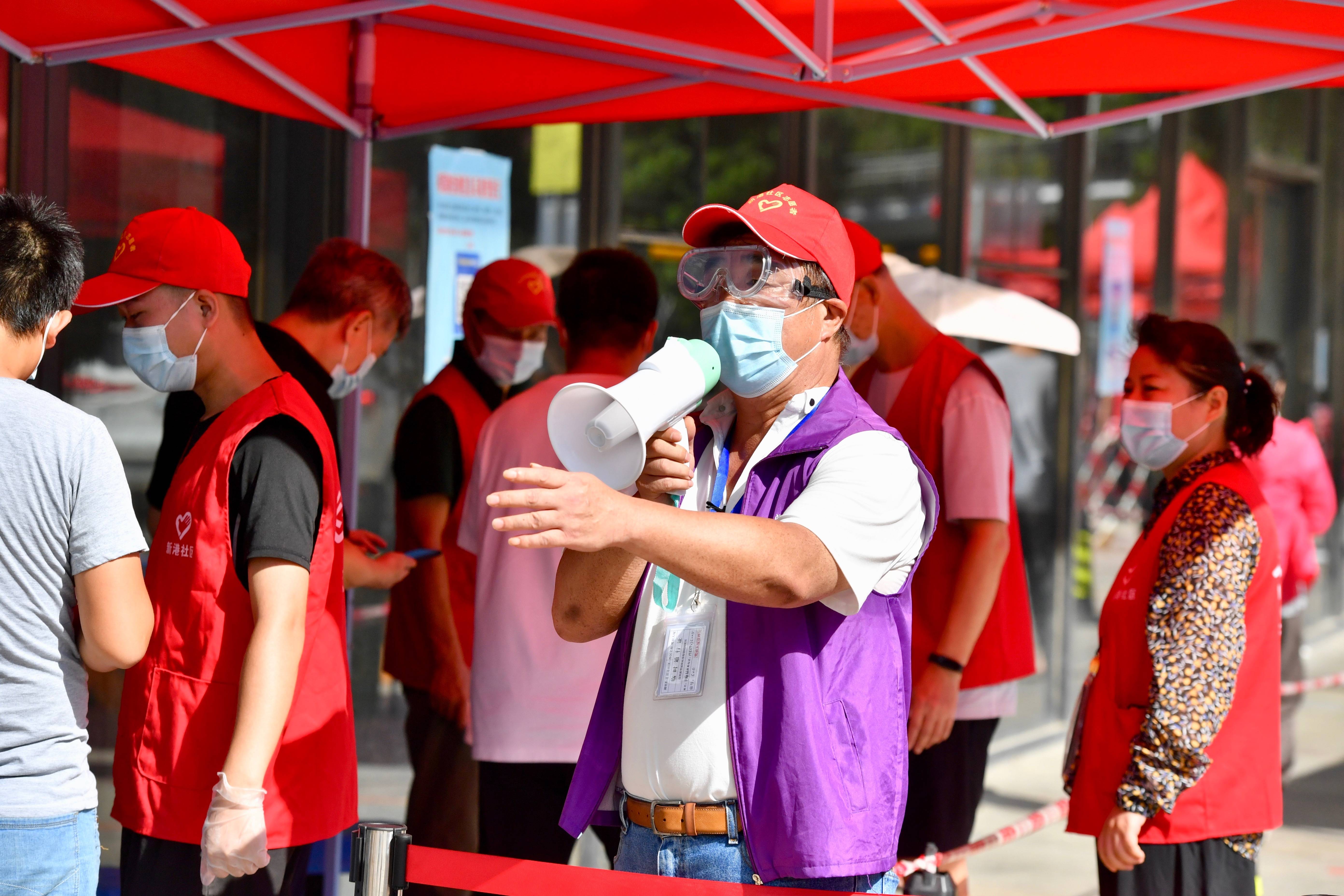9月22日,在厦门思明区一核酸检测点,台胞志愿者毛维林(前)在引导市民