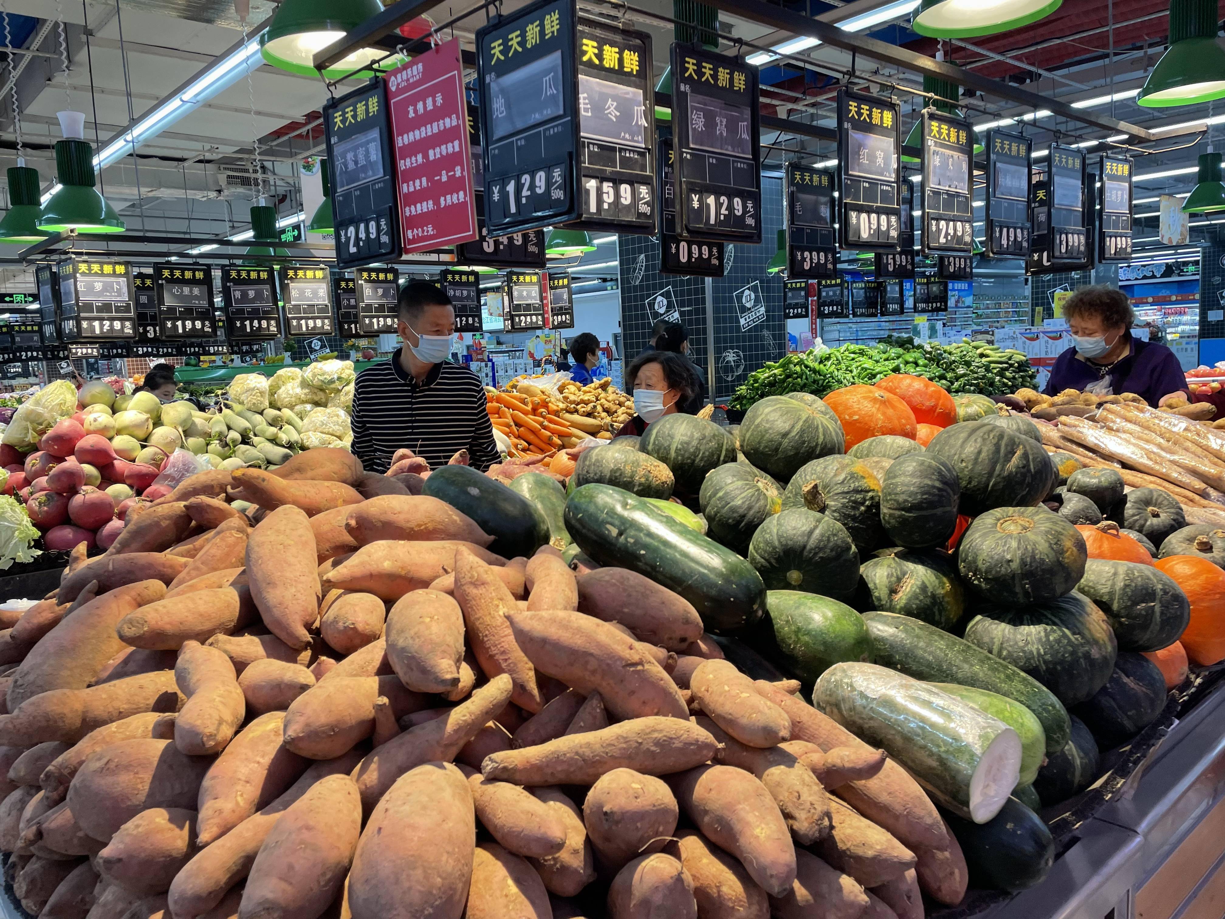 哈市超市肉禽蛋奶蔬菜供应充足,价格便宜,市民戴口罩测温后进入