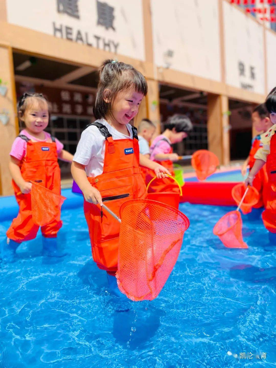 他们眼紧盯水池里的小金鱼,利用手中的"大网"认真的捕着小金鱼,一幅人