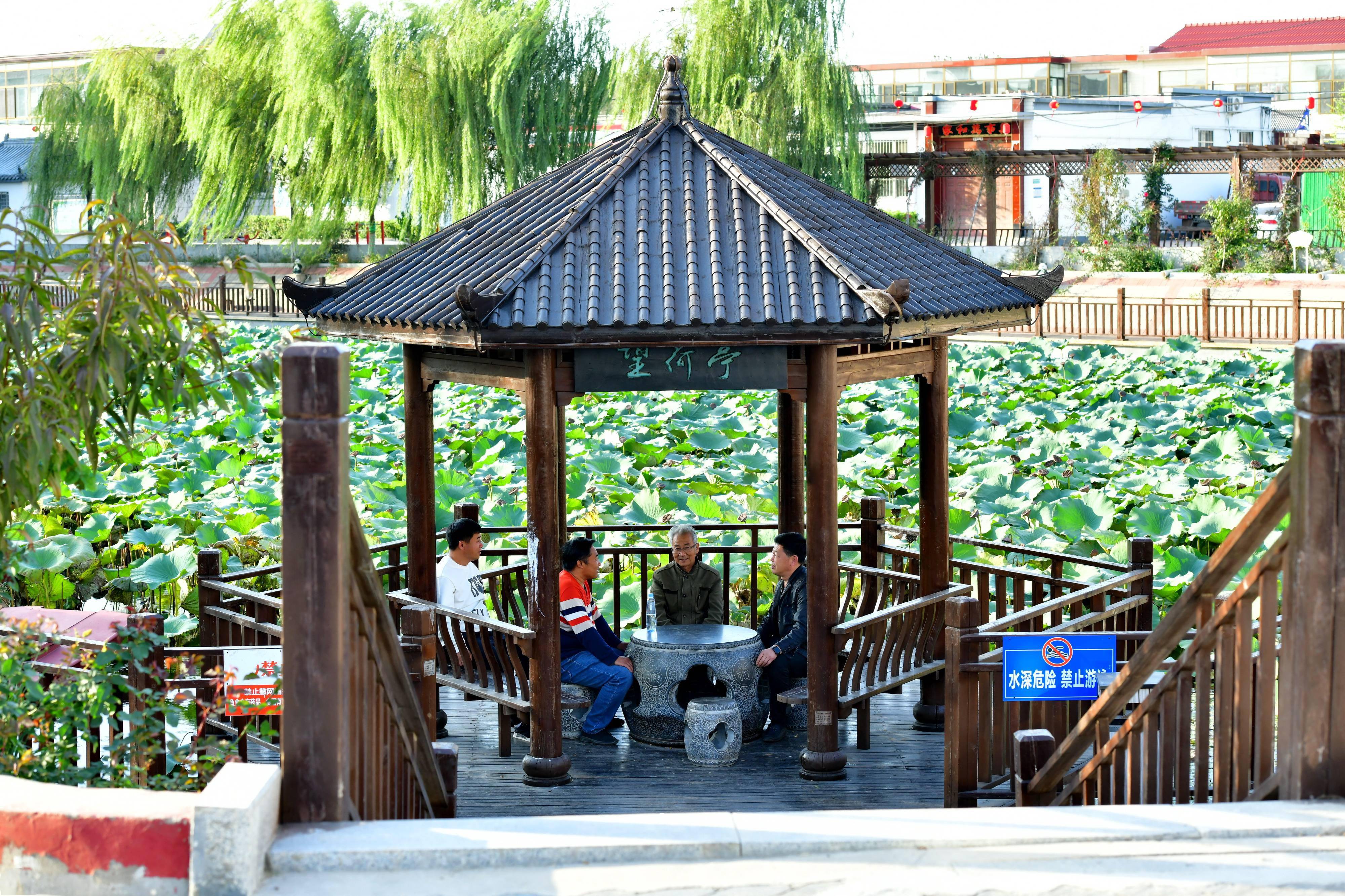 10月16日,村民在河北省任丘市东关张村的游园内聊天.