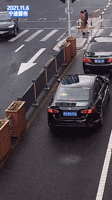 一个十字路口,一辆黑色轿车等待红灯时,驾驶员多次将车内垃圾扔出窗外