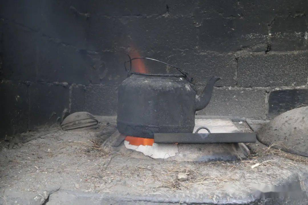 松毛的大火燃烧可以将土灶均匀受热,这时在灶台上烧上一壶热水,充分