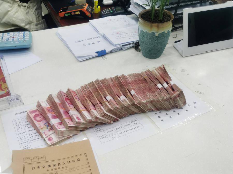 快执团队办公室,被执行人陈某将20万元现金放到了法官助理小王的桌上
