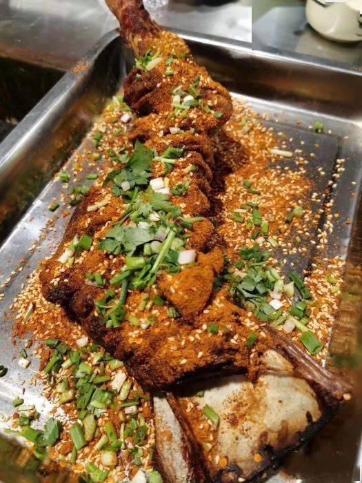 炉架上不停地翻烤,直到油滋啦啦的滴下来,羊肉也因火的炙烤而变得金黄