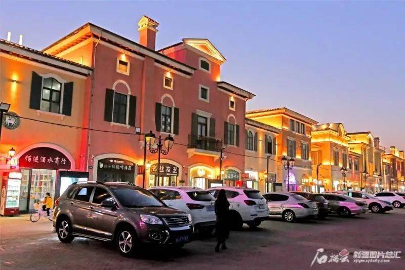 初冬的夜晚,气温逐渐走低,但在哈密市伊州区迎宾大道旁的皇后天街夜市