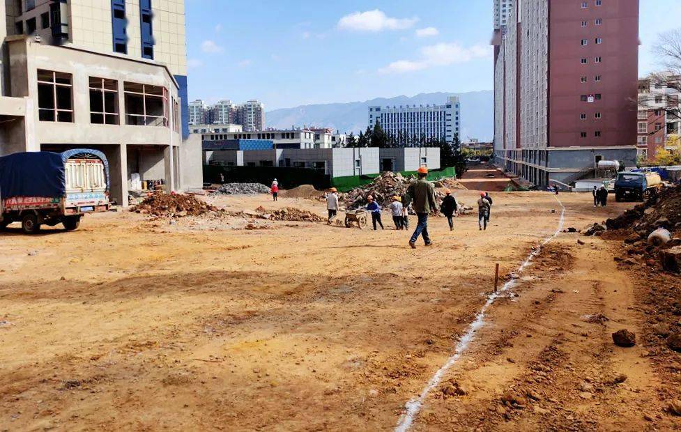 在新南路施工现场,工作人员正在使用石灰划线规划道路走向,挖机也在