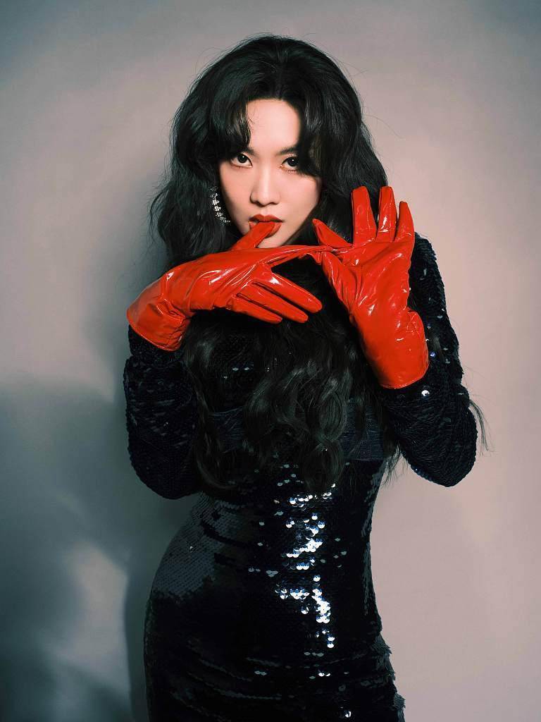 王霏霏出席芒果年货节复古波浪卷发搭配亮面红手套摩登感十足