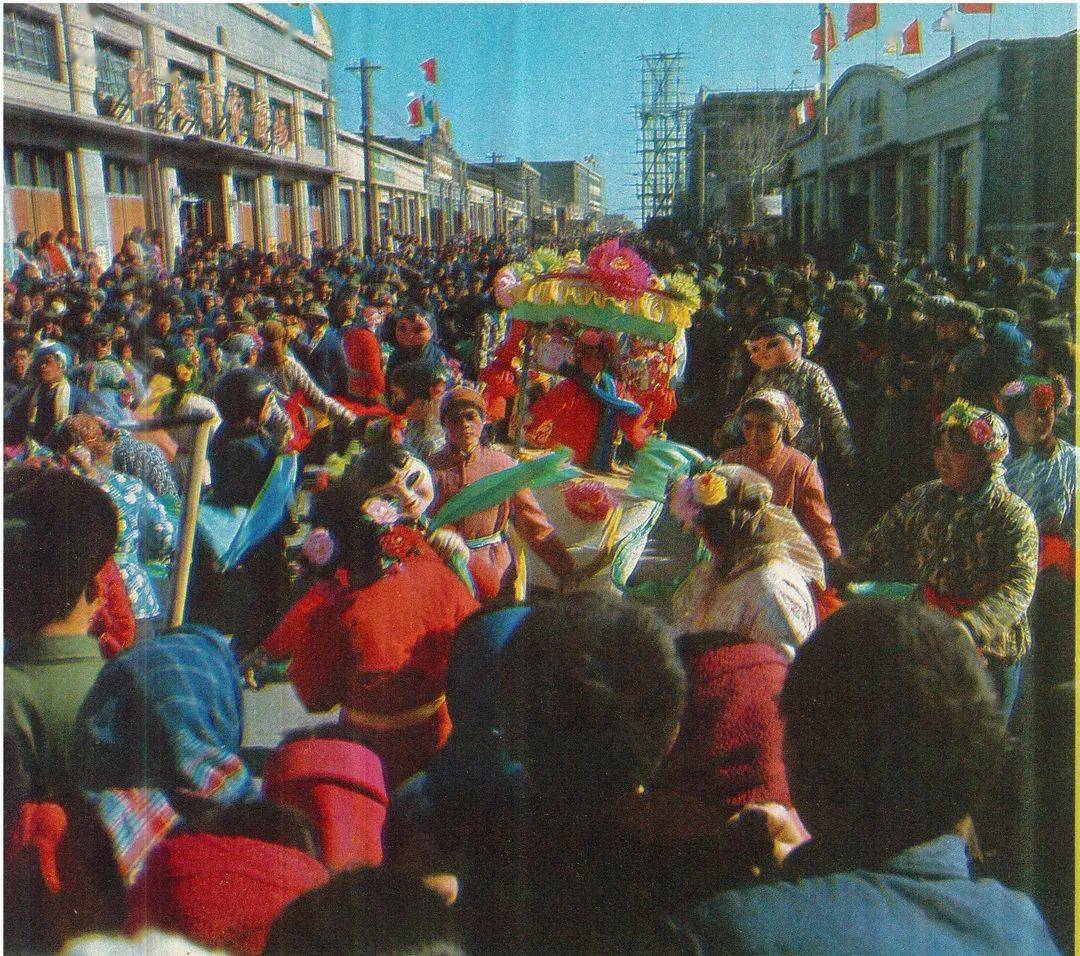 (《人民画报》1978年第五期)春节清晨,一家人在门口放鞭炮,辞旧迎新.