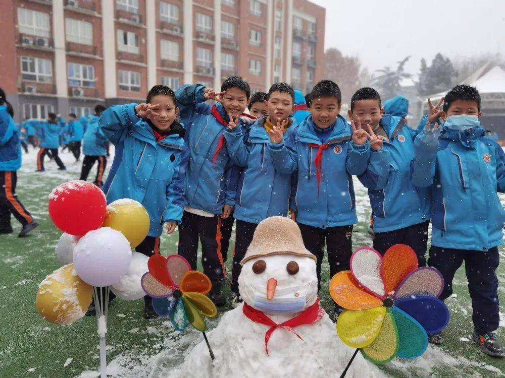 西安市星光实验学校校园操场上同学们在雪地里奔跑.