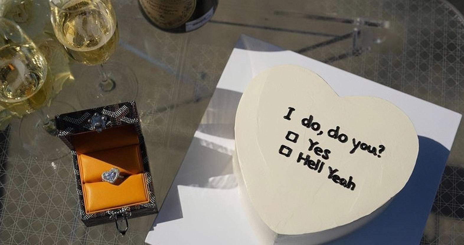 他提前准备了一个白色的心形蛋糕,上面用英文写着:我愿意,你愿意吗?