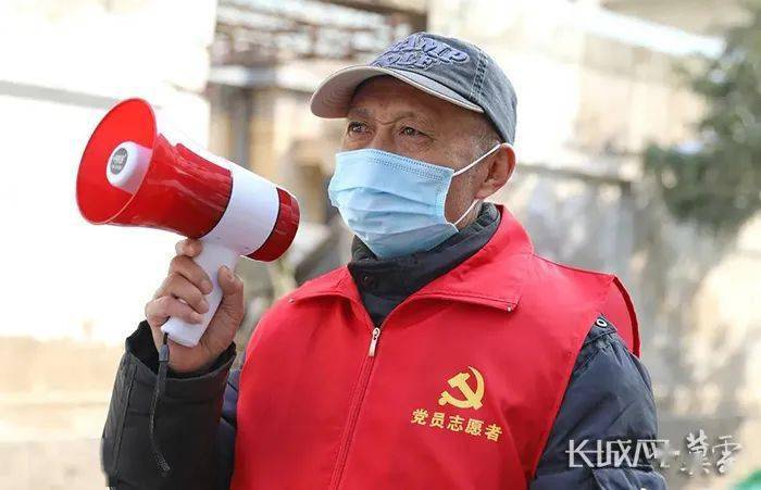 正社区里巡逻的于胜利。72岁的于胜利熟练地穿上志愿者红马甲，拿上小喇