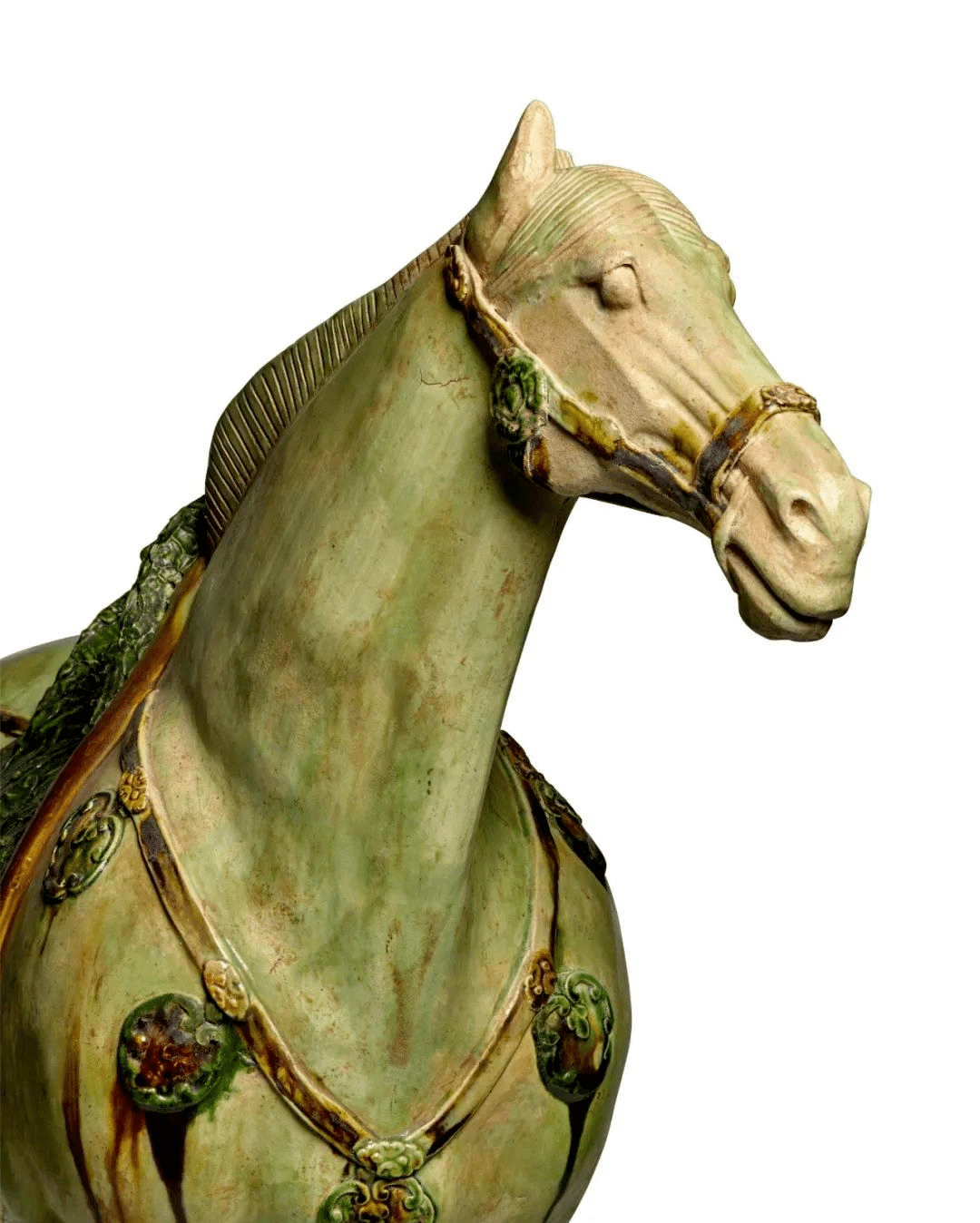 马头高昂戴辔头,双耳竖立,眼睛圆睁,闭口,马鬃剪齐,上饰菱格纹,颈后部