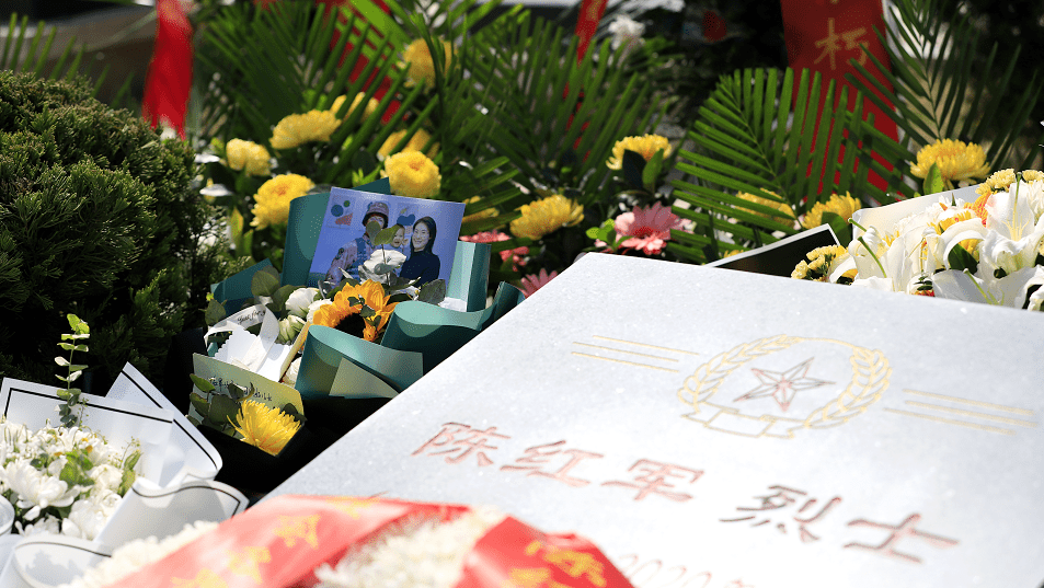 有来自社会各界的群众敬献的鲜花和留言卡在陈红军烈士的墓碑前王佛军