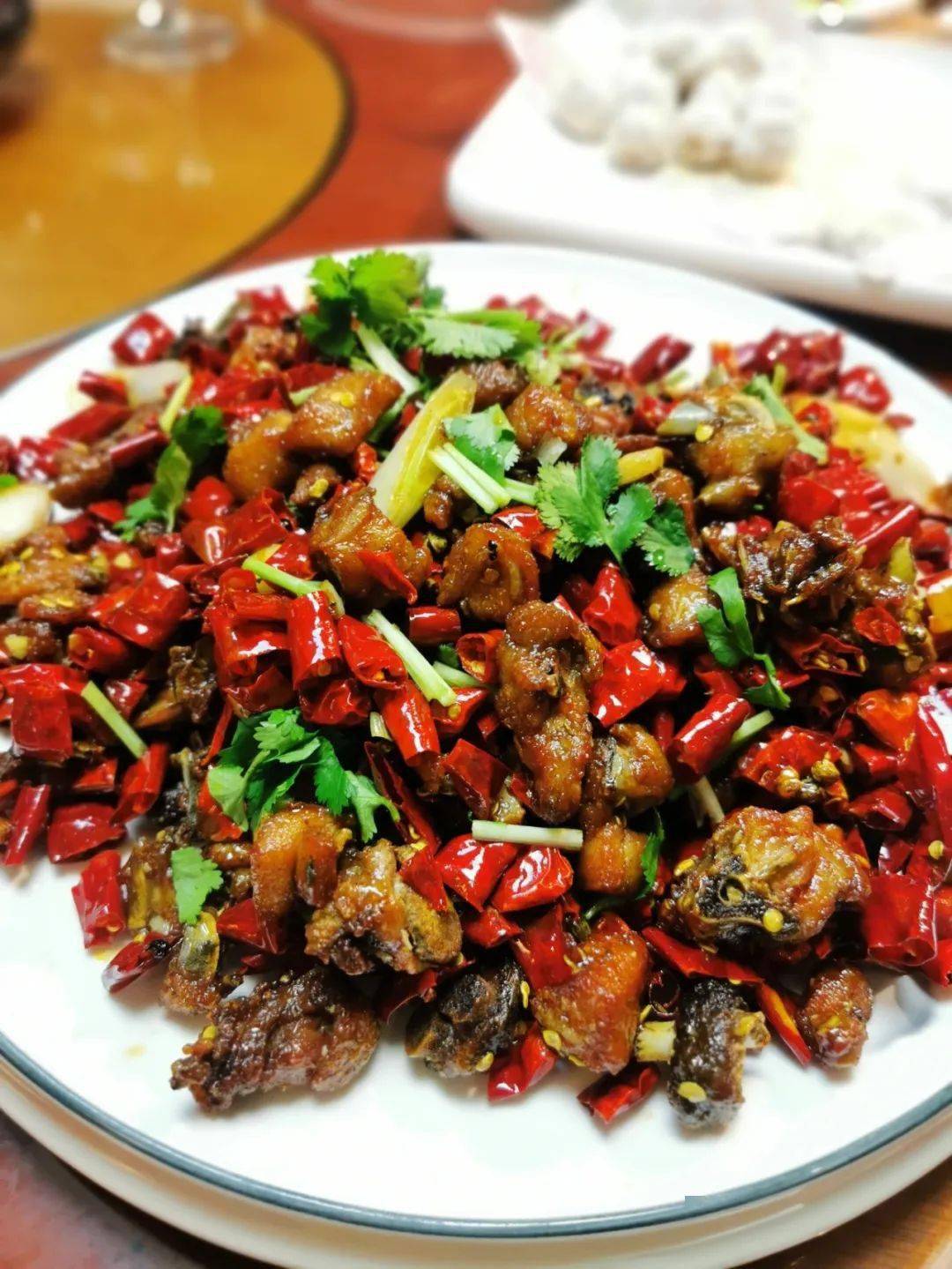 干煸辣子鸡出锅时色泽鲜亮,肉质饱满,外皮炸的很焦脆,香酥可口.