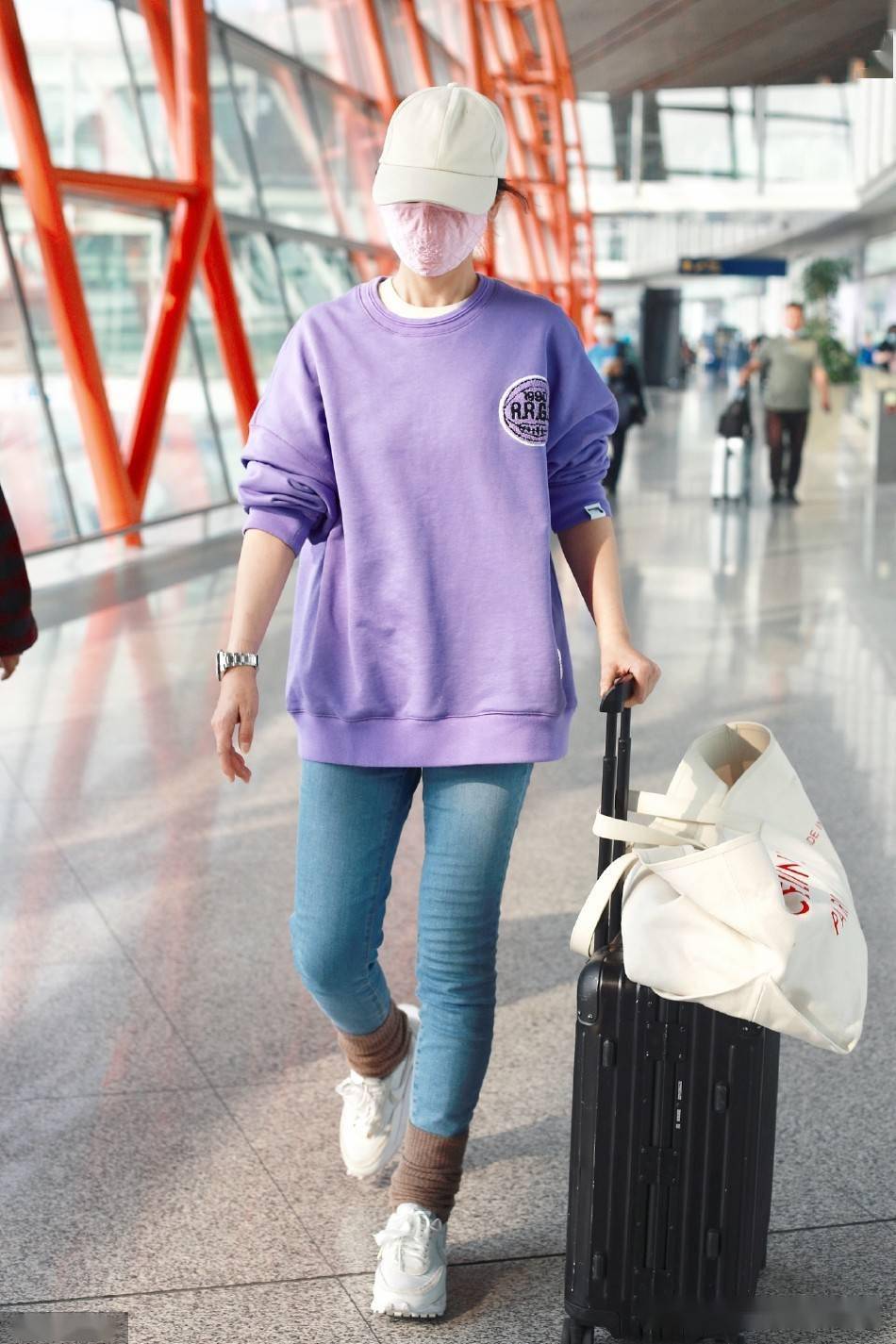 演员海清现身北京机场穿紫色卫衣搭棒球帽低调休闲