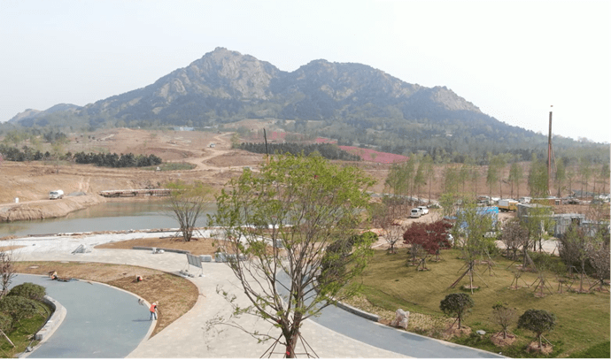 在日照奎山山地公园建设现场,工程车辆来回穿梭,轰鸣声不绝于耳,配合
