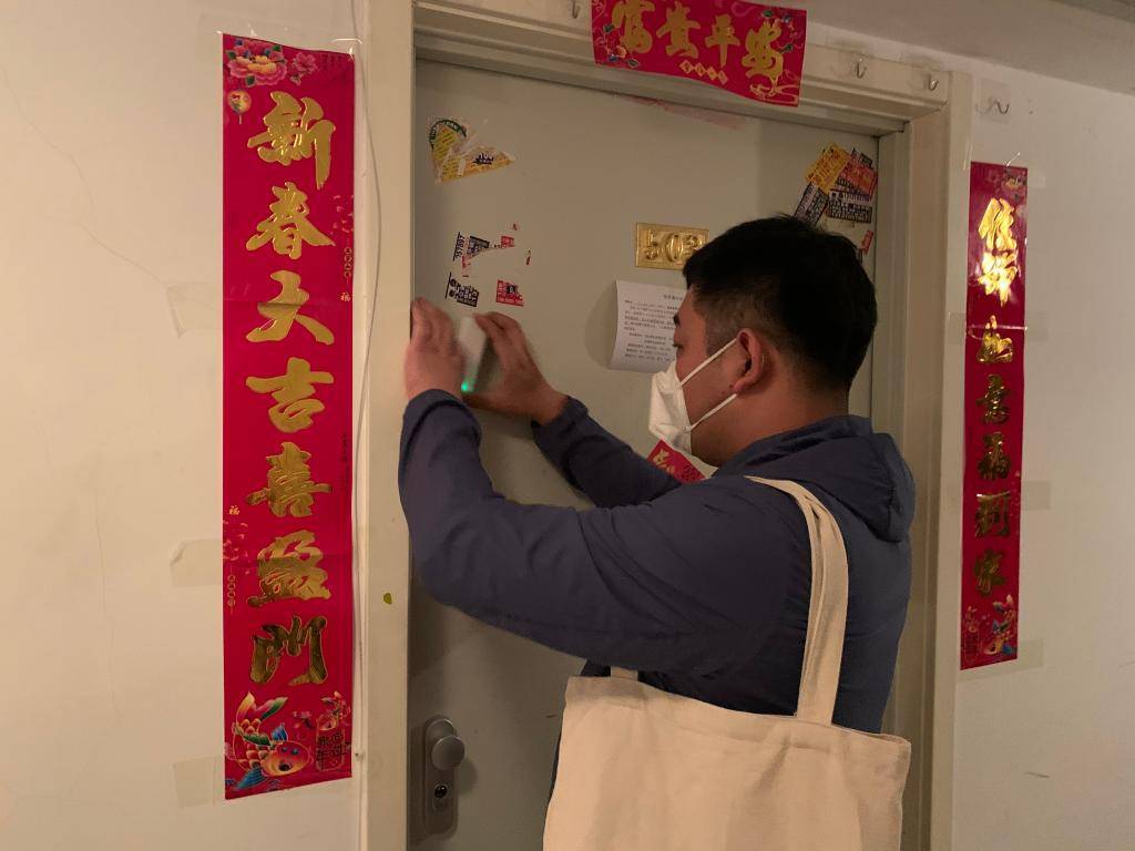 赵鹏为居家隔离居民安装门磁.