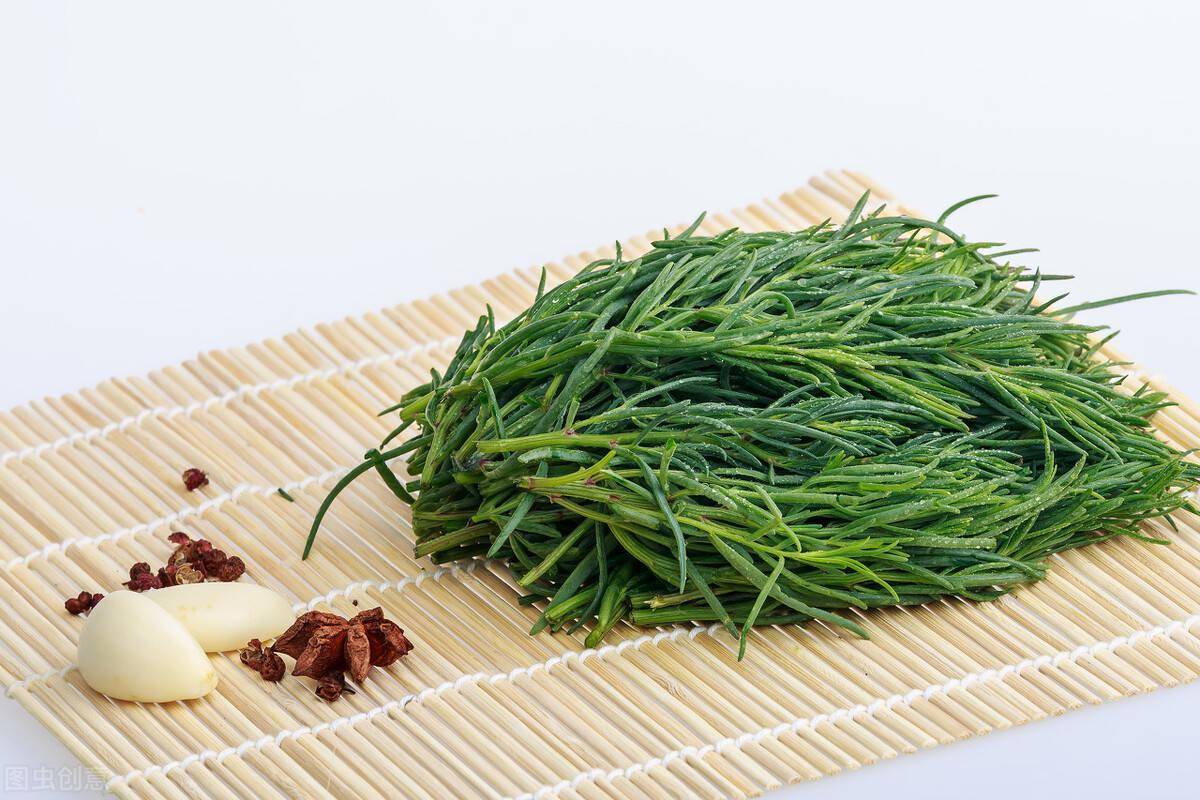 把黄须菜放在大碗里,倒入适量的食用油搅拌均匀,拿一块猪肉剁成肉馅