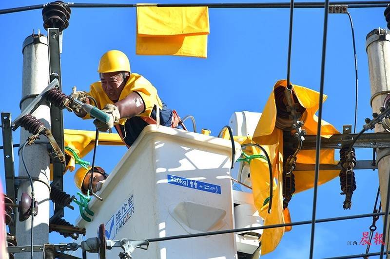 為確保迎峰度夏期間用電安全,電力工人頭頂烈日在高空檢修線路.