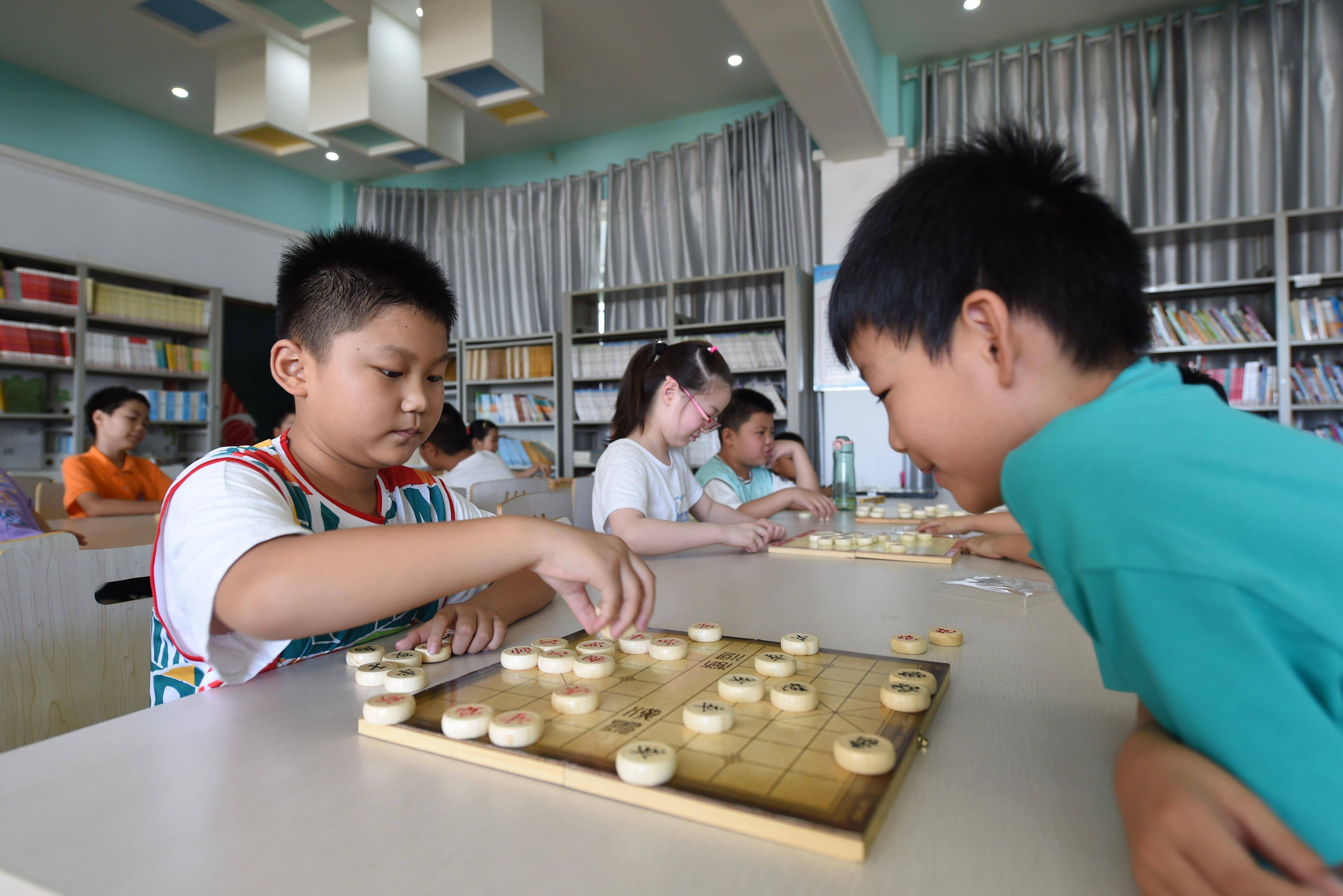 8月11日,合肥市蜀新苑小学的学生在暑期托管班里学习下象棋.