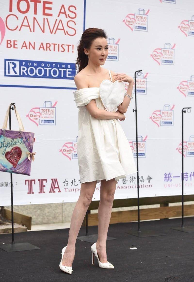 下图照片中,萧蔷穿了一件白色t恤加浅紫色百褶短裙加深蓝色丝袜,整体