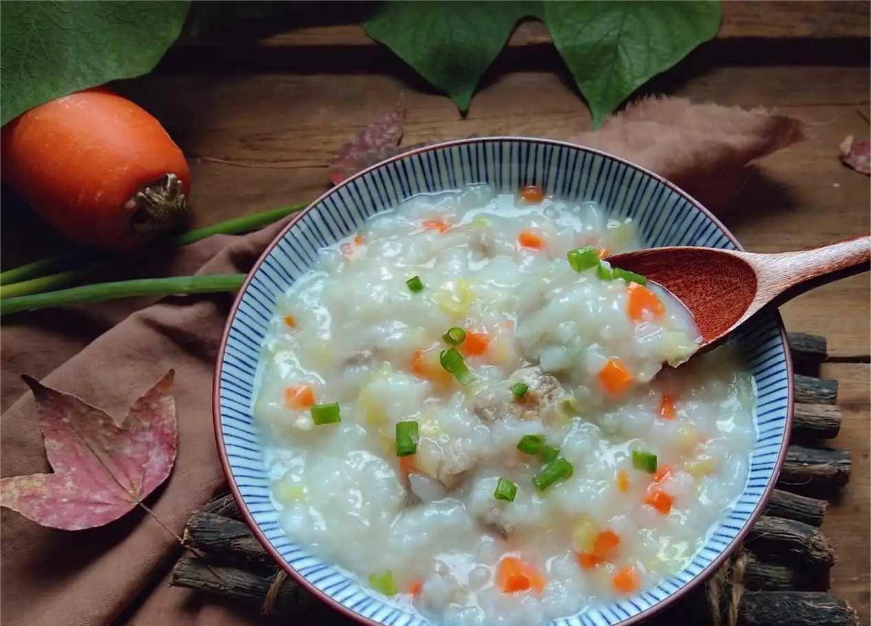 6,往锅里面倒入适量的水,烧开后放入胡萝卜和山药,煮一会儿,放入米饭