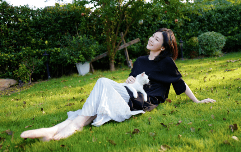 42岁童蕾赤脚坐草地撸猫,穿百褶裙气质优雅,四肢纤细身材苗条_小猫