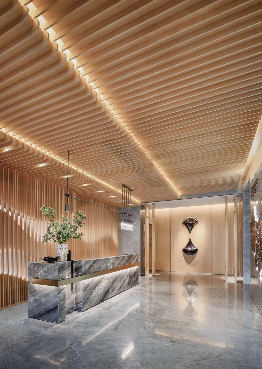 前台接待区采用动态流动的设计手法营造出层叠变换的山水形态,在镂空
