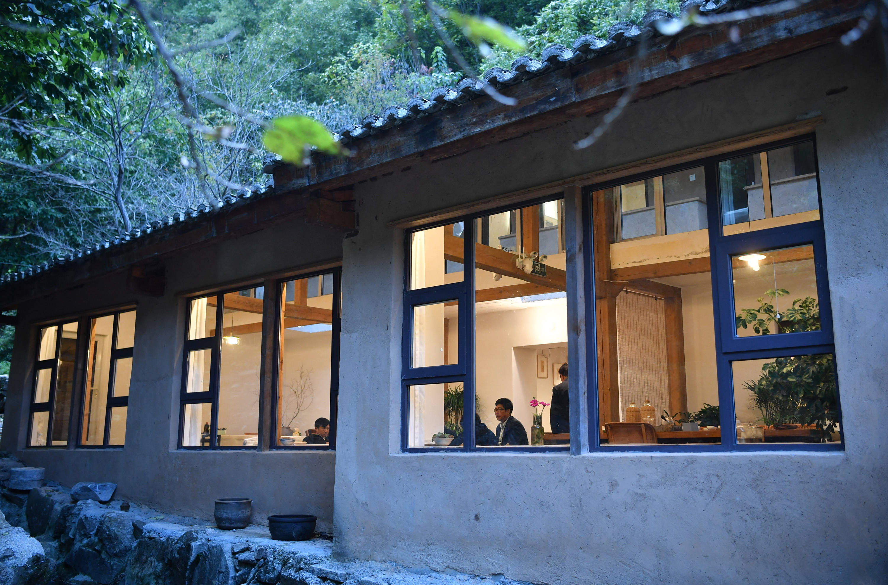 游客在宁陕县广货街镇沙沟村由闲置破旧农房改造而成的民宿中休息聊天