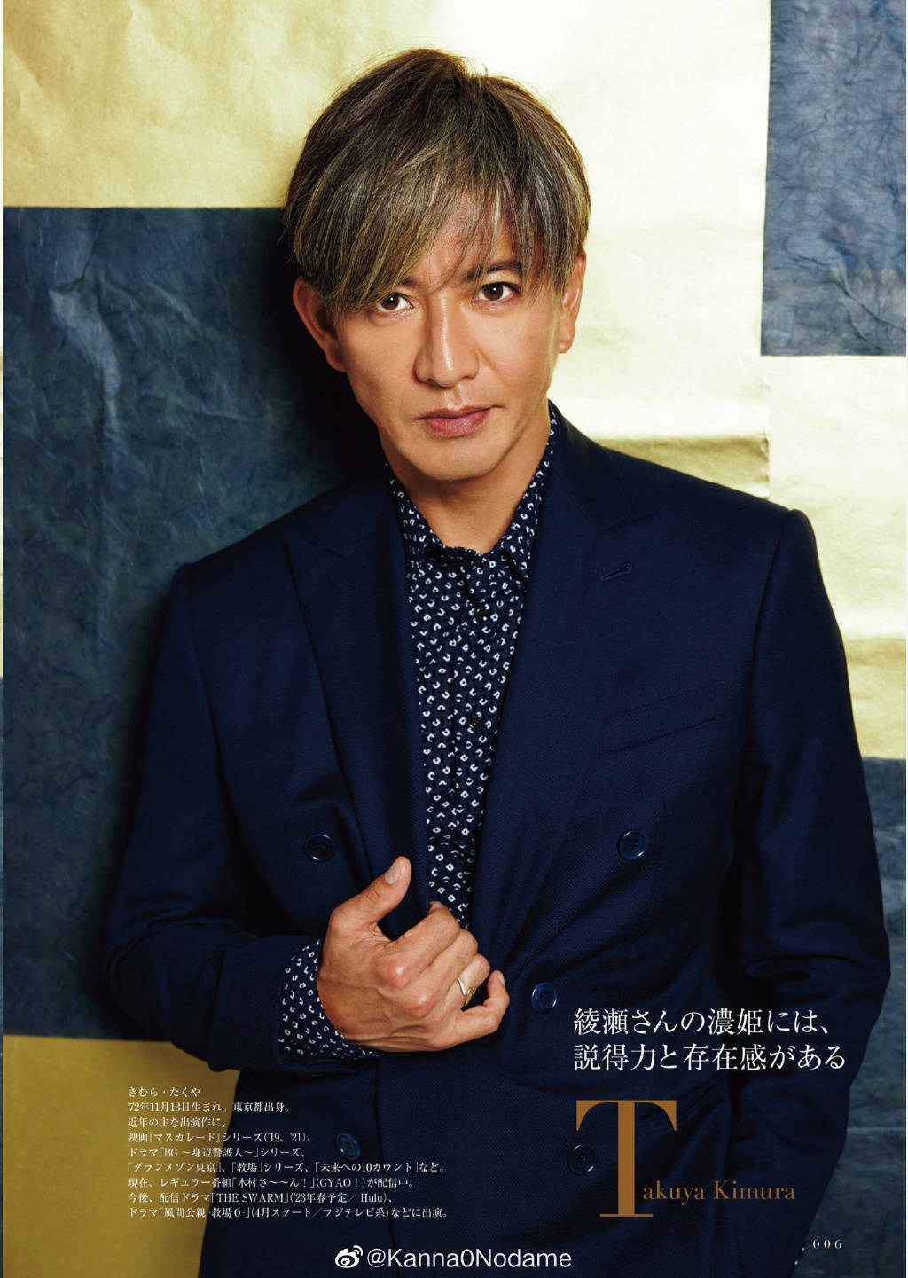 木村拓哉身穿蓝色西服衣裤,搭配蓝白斑点衬衫,他脸颊冷俊,鼻子挺拔,染