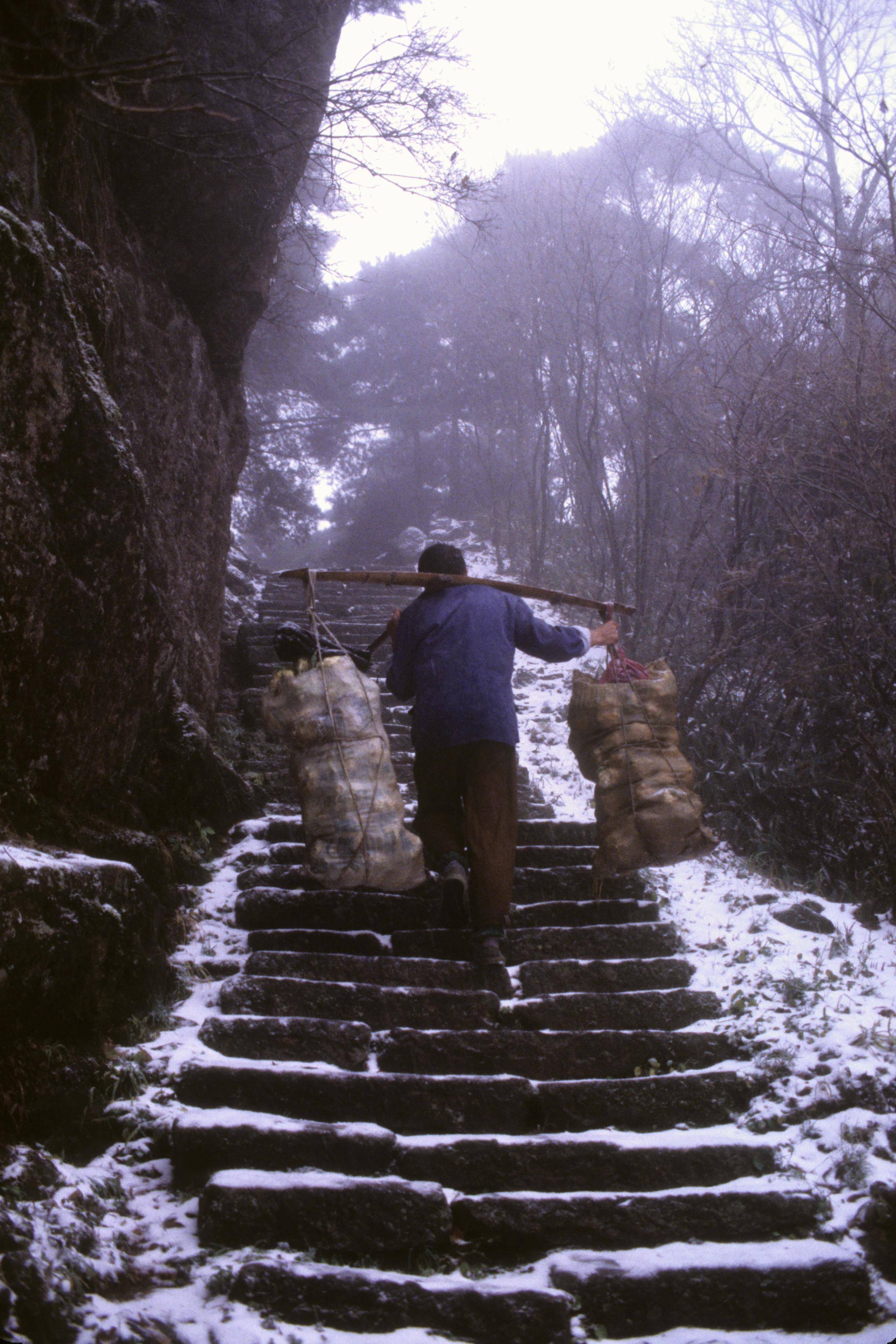 hila拍摄,在十一月八日的登山道上,是一场雪后,一位黄山挑山工正挑着